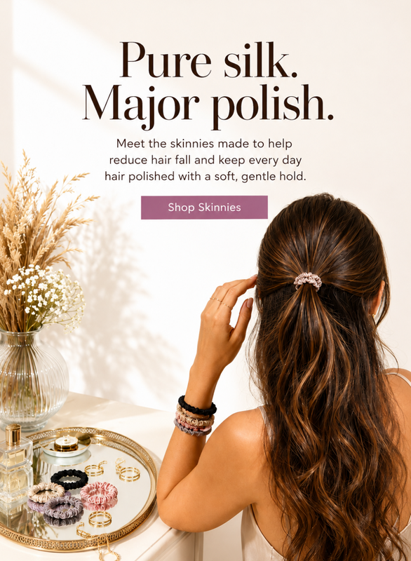 A woman with long wavy brown hair is shown from behind, wearing a pink scrunchie in her hair. The scene is styled with a tray of hair accessories and dried flowers on a table, with text reading 'Pure silk. Spotstyl Pure Mulberry Silk Scrunchies